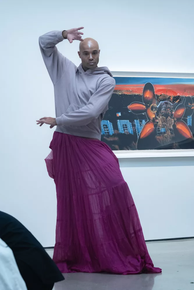 Tara Subkoff's IoC performer in purple skirt and gray hoodie