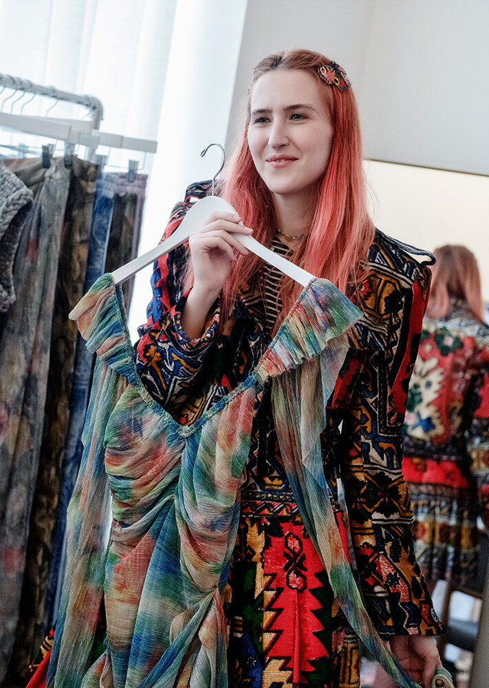 Emerging fashion designer Mia Vesper holding up a dress