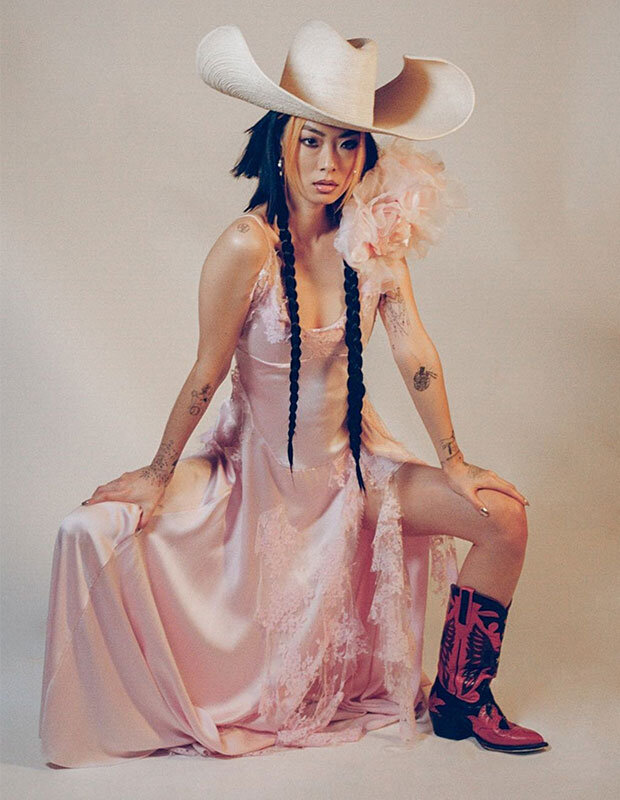 Rina Sawayam in a pink slip dress and cowboy hat and boots