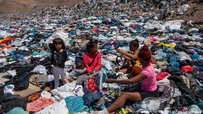 People surround by discard clothes in Atacama desert.