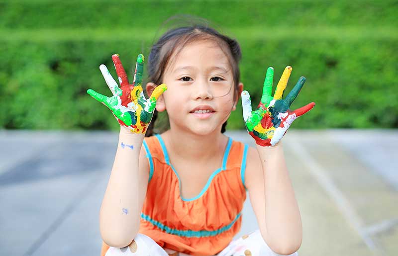 A child with paint all over her hands -authentically imperfect