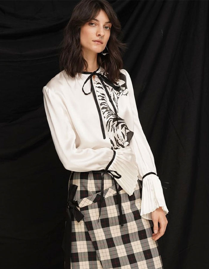 Model wears Snow Xue Gao blouse and tartan skirt in custom prints
