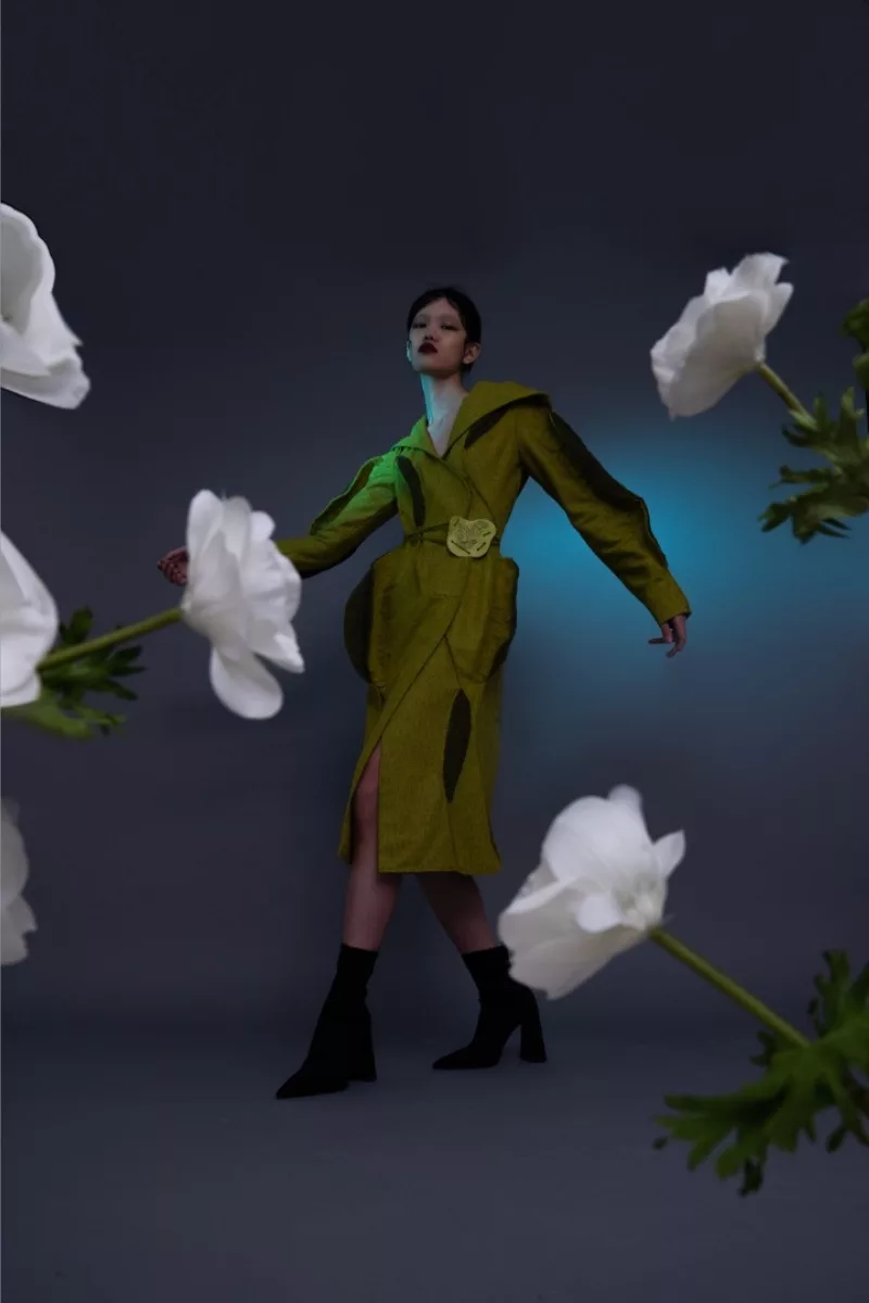 A model wearing a green dress full length image from Wenxin’s BFA thesis collection from Parsons fashion school