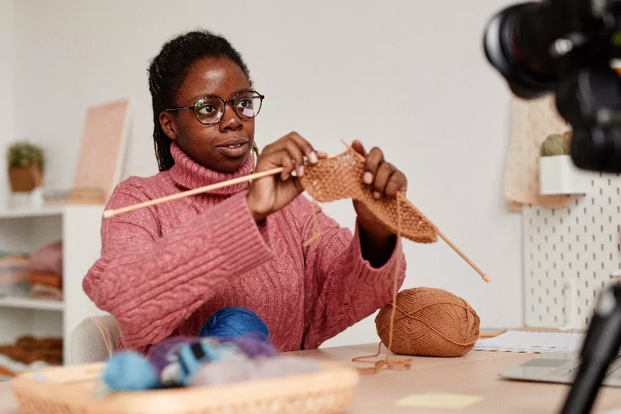 young woman streaming her knitting instruction