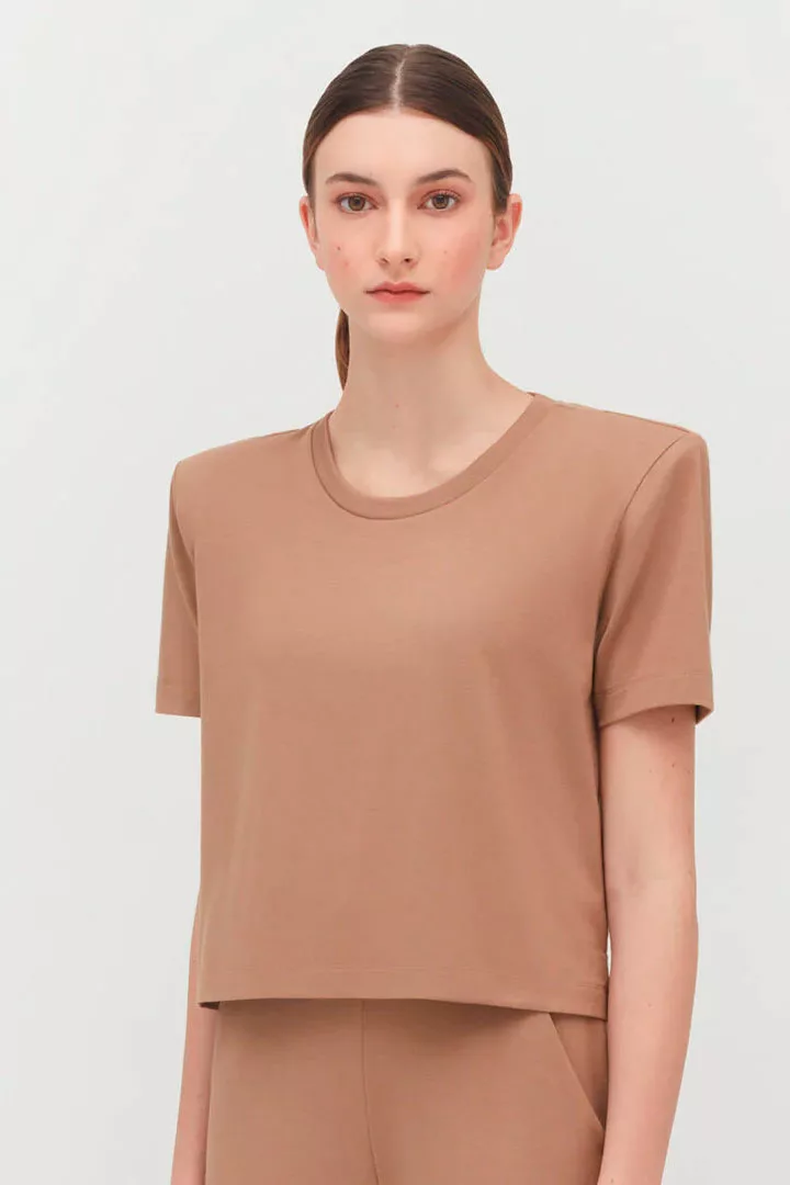 woman in tan cuyana cropped tee with shoulder pads
