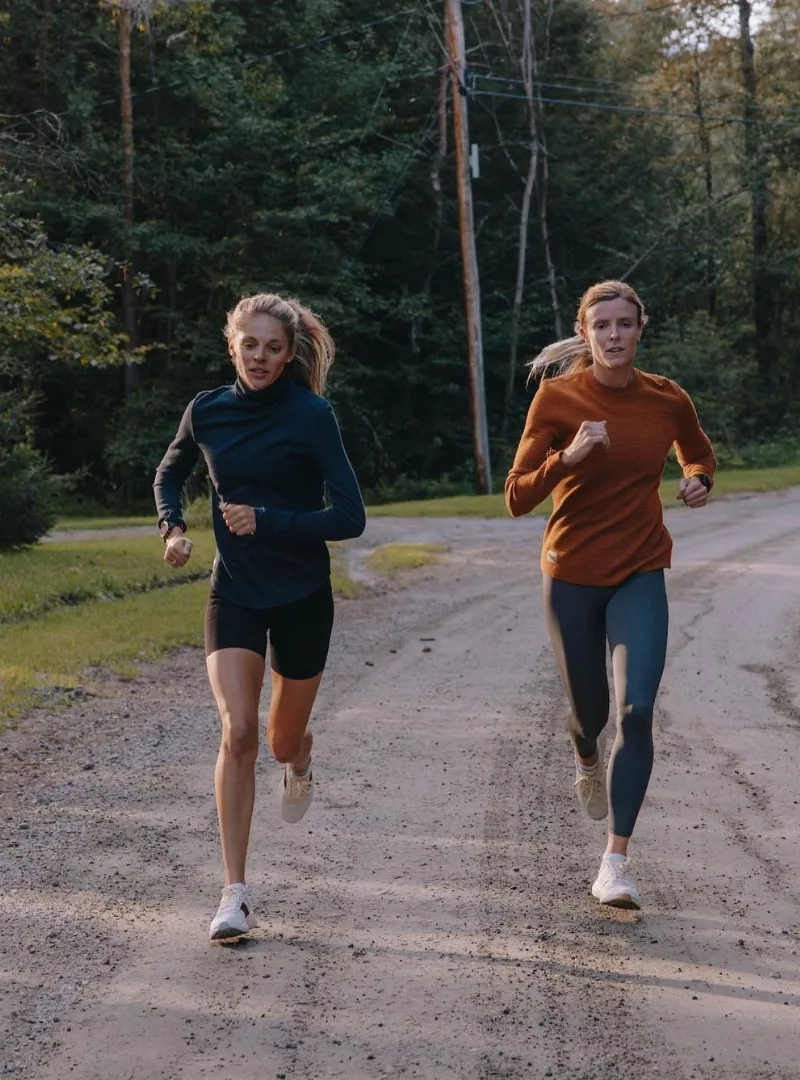 two women running down a country road