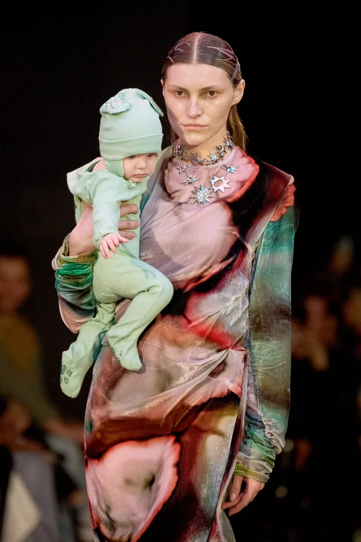 woman carrying a baby as she walks  on collina strada fw24 runway